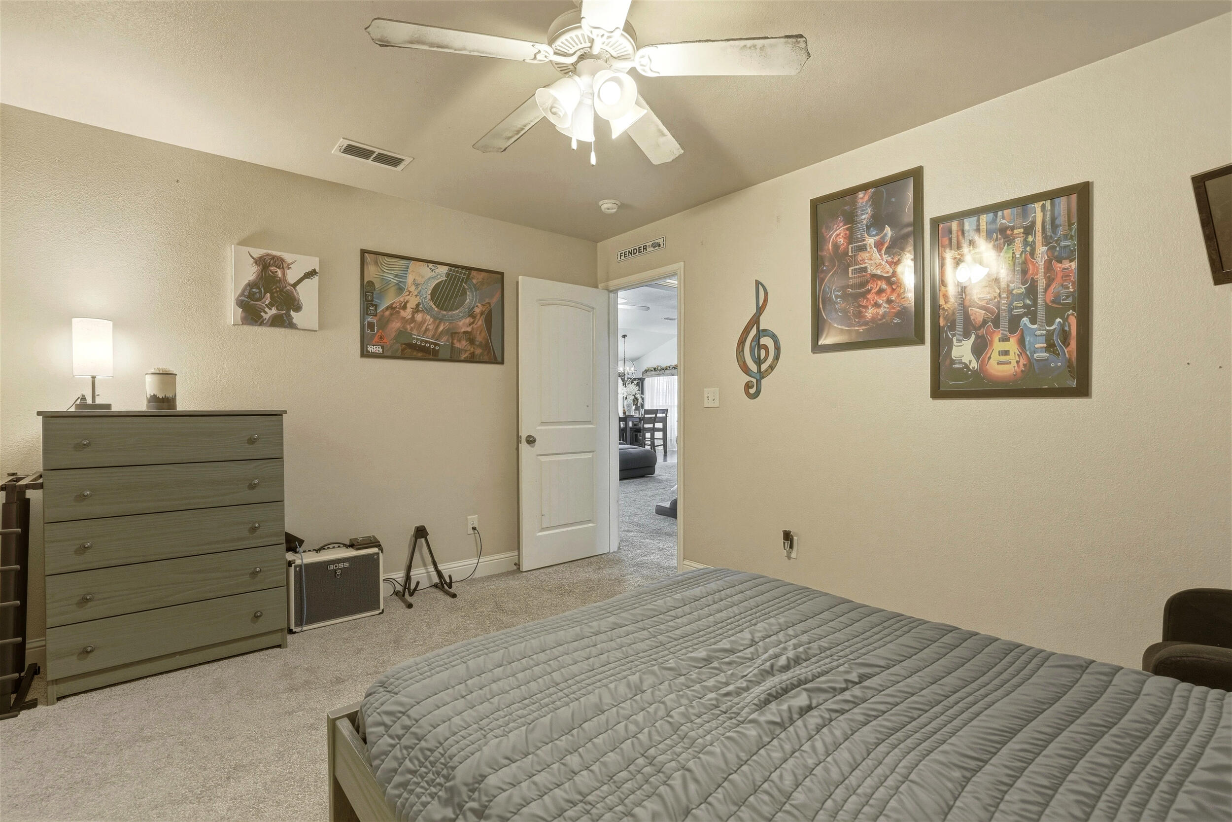 8808 Rochester Avenue Lubbock, TX 79424 - Photo 22 of 27 a bedroom with a bed and a chandelier