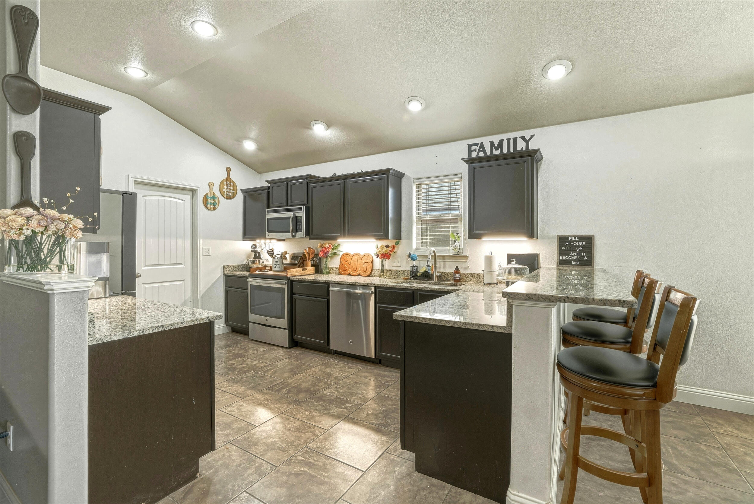 8808 Rochester Avenue Lubbock, TX 79424 - Photo 9 of 27 a kitchen with refrigerator and chairs