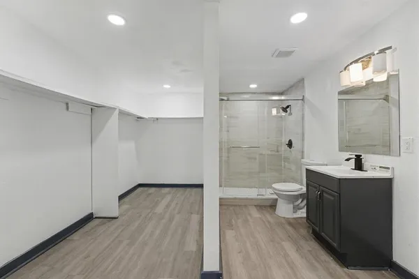 a bathroom with a sink a toilet and shower