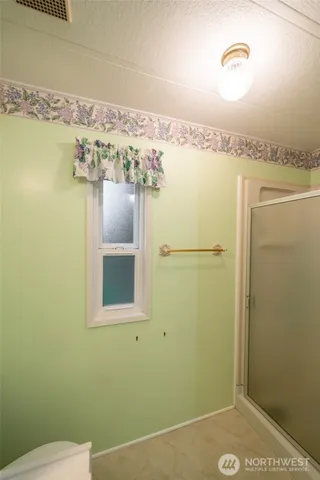 a bathroom with a window and a shower