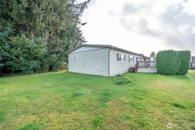 a view of a backyard with barn plants and large tree