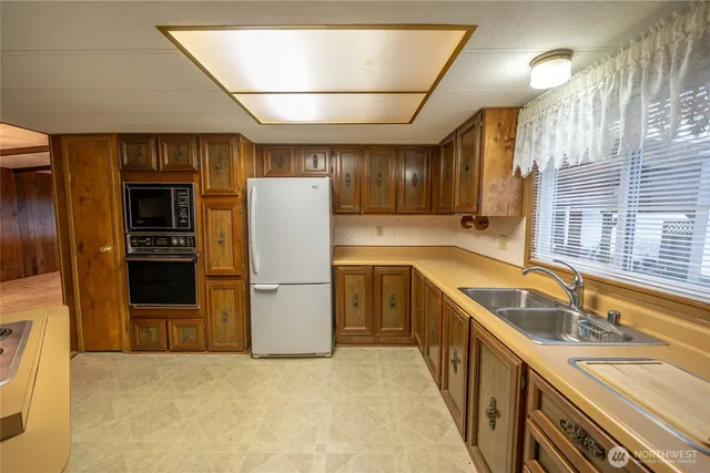 a kitchen with a sink a refrigerator and cabinets