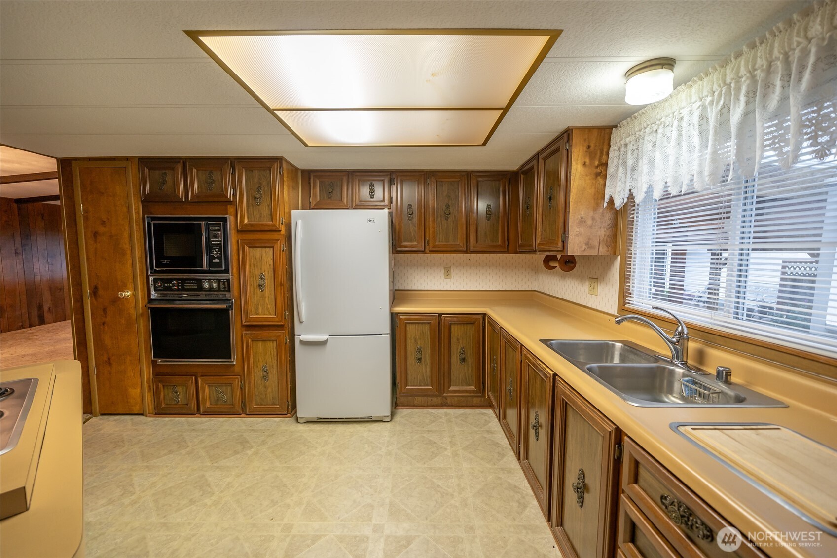 57 Clemons Road, Unit 64 Montesano, WA 98563 - Photo 8 of 35 a kitchen with a sink a refrigerator and cabinets