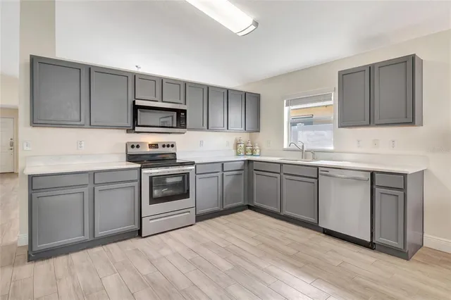 a kitchen with a sink cabinets and stainless steel appliances