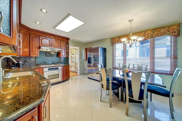 a kitchen with sink refrigerator dining table and chairs