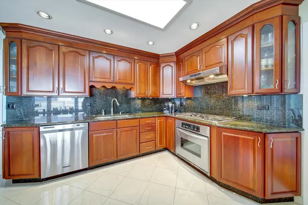 a kitchen with stainless steel appliances granite countertop a stove sink and cabinets
