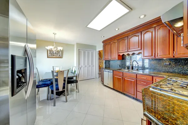 a kitchen with stainless steel appliances granite countertop a refrigerator a sink a stove and island
