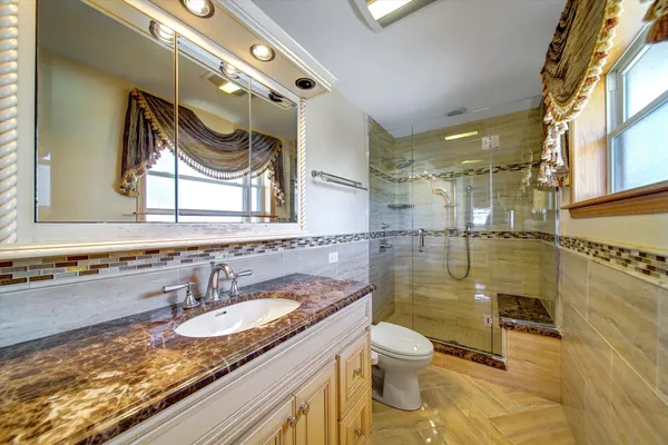a bathroom with a granite countertop sink and a mirror