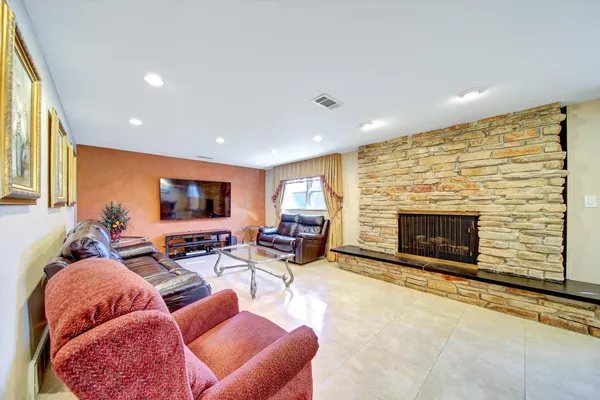 a living room with furniture a fireplace and a flat screen tv