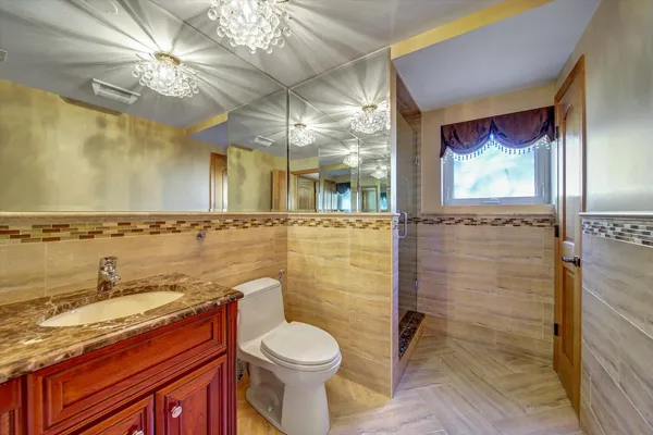 a bathroom with a granite countertop sink a toilet and shower