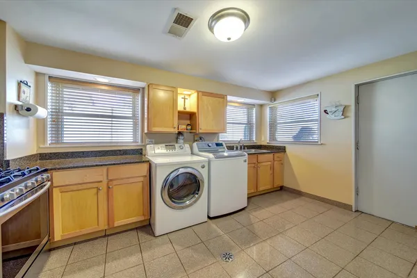 a utility room with sink dryer and washer