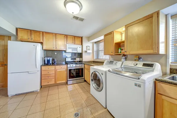 a kitchen with a sink a stove a refrigerator and washer