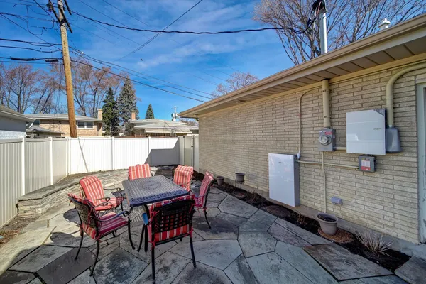 a patio with table and chairs and potted plants