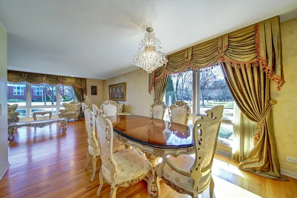 a dining room with furniture a chandelier and wooden floor