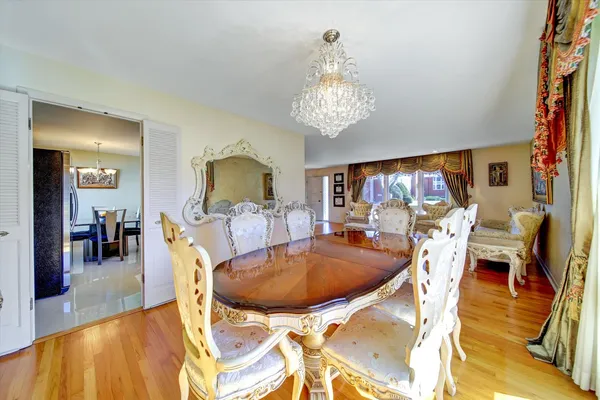 a view of a dining room with furniture a chandelier and wooden floor