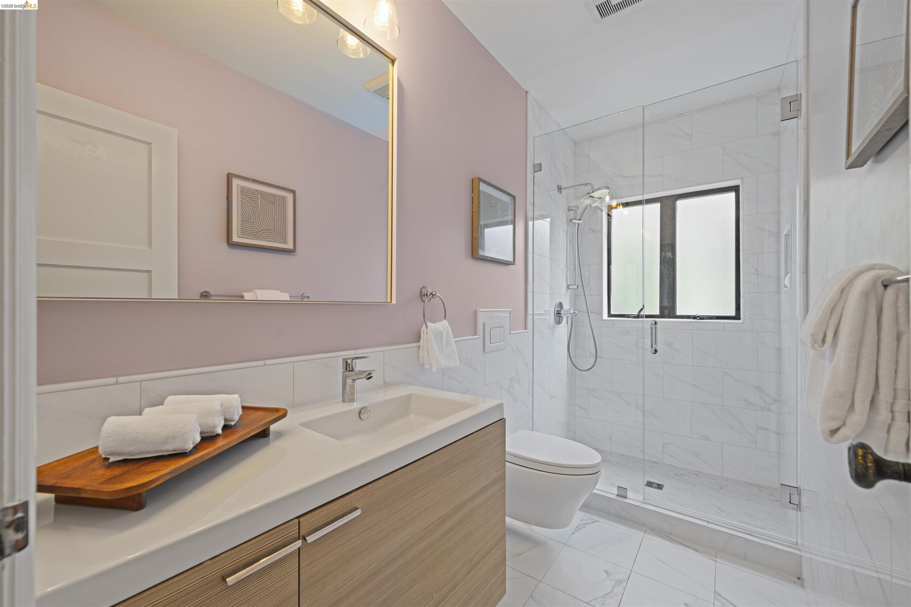 1170 Sterling Avenue Berkeley, CA 94708 - Photo 23 of 52 Full bath with vanity, a stall shower, light marble finish floors, tile walls, and wainscoting