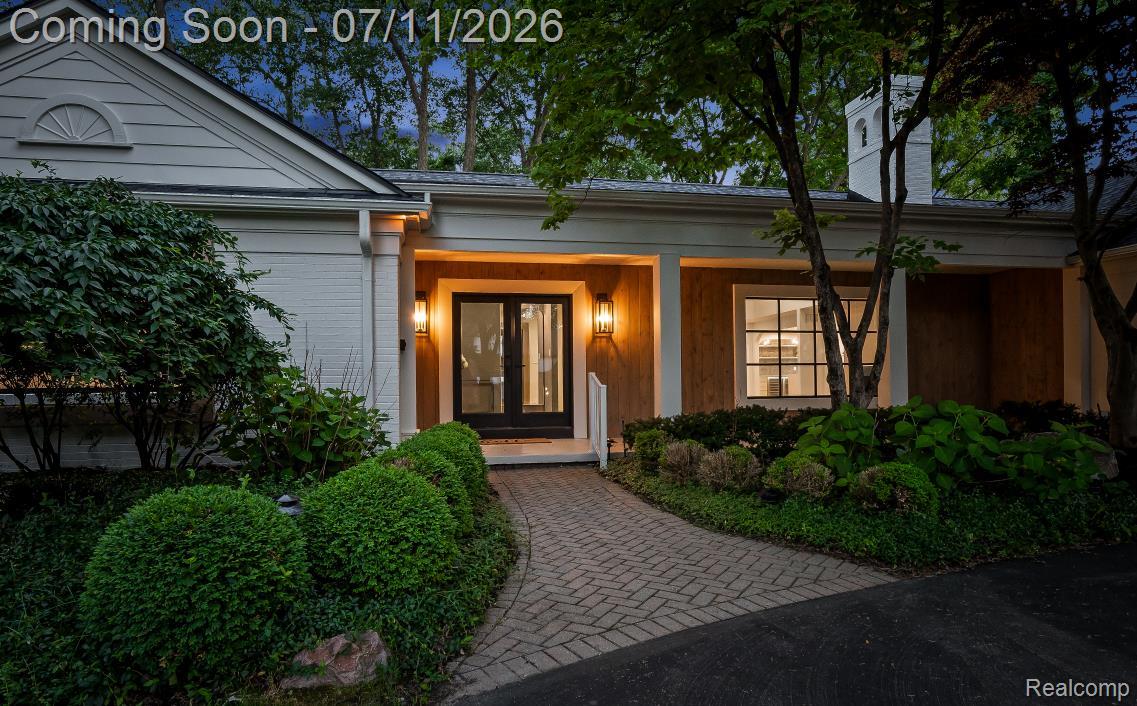 4154 Nearbrook Road Bloomfield Hills, MI 48302 - Photo 3 of 47 Brick paver walkway leading to a covered entry with dual glass panel doors, illuminated by exterior sconces