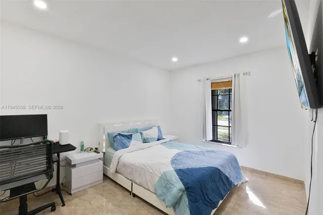 a bedroom with a bed and a flat screen tv