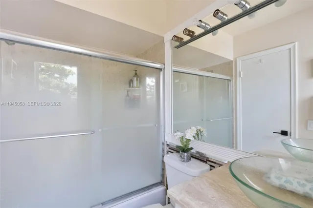 a bathroom with a granite countertop shower and a sink