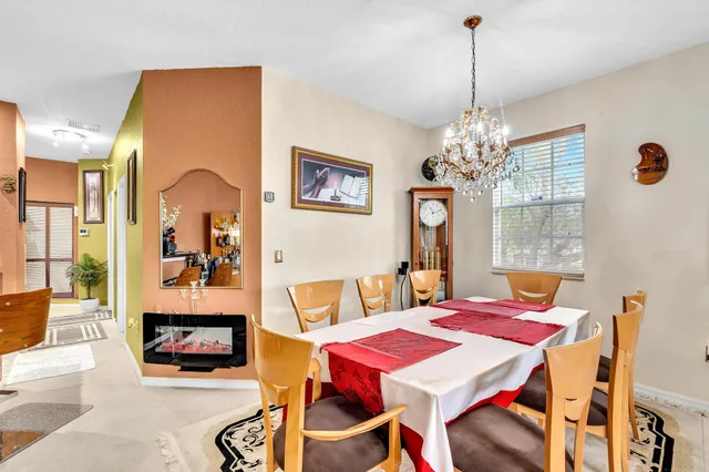 a view of a dining room with furniture a chandelier and wooden floor