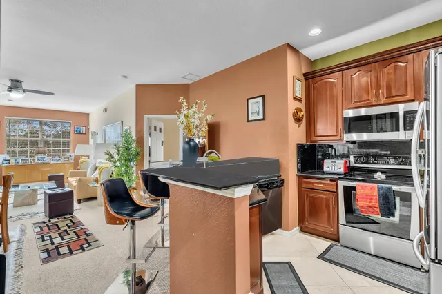 a kitchen with stainless steel appliances granite countertop a stove top oven a sink dishwasher and cabinets with wooden floor