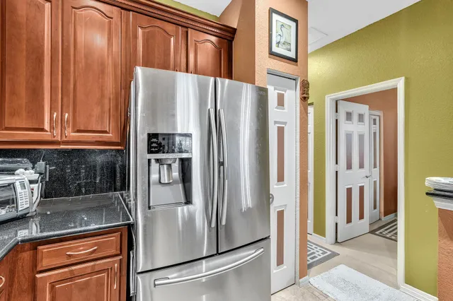 a kitchen with stainless steel appliances granite countertop a refrigerator and a stove top oven