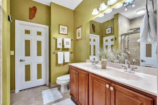 a spacious bathroom with a sink a toilet and a large mirror