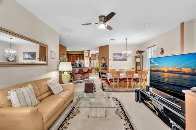a living room with furniture kitchen view and a window