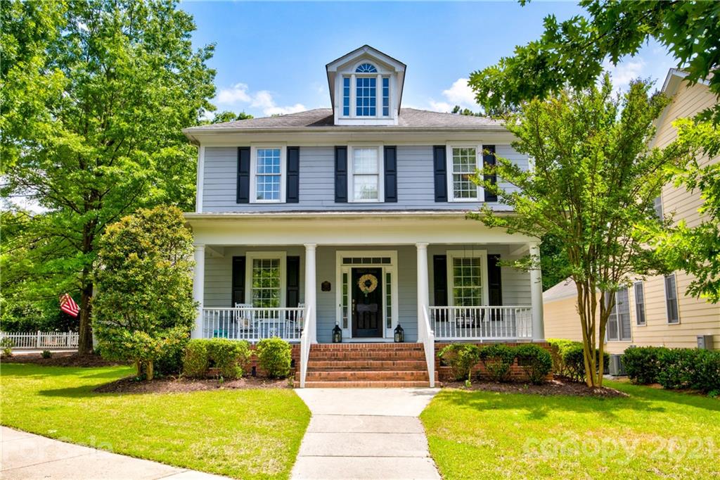 a front view of a house with swimming pool and porch