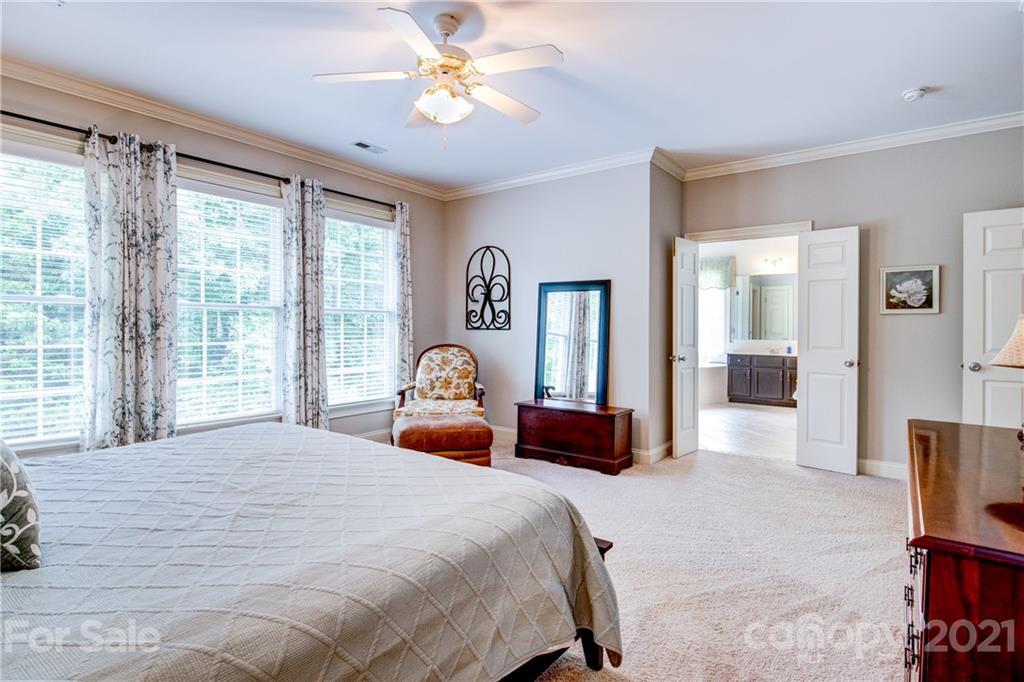7155 Michael Scott Crossing Fort Mill, SC 29708 - Photo 20 of 41 a bedroom with a large bed and a chandelier