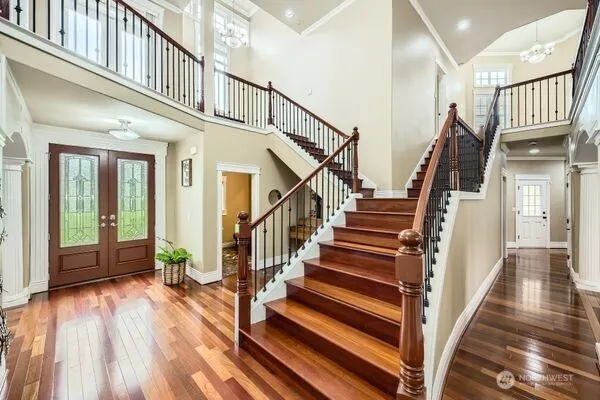 a view of staircase with lots of frames on wall and wooden floor