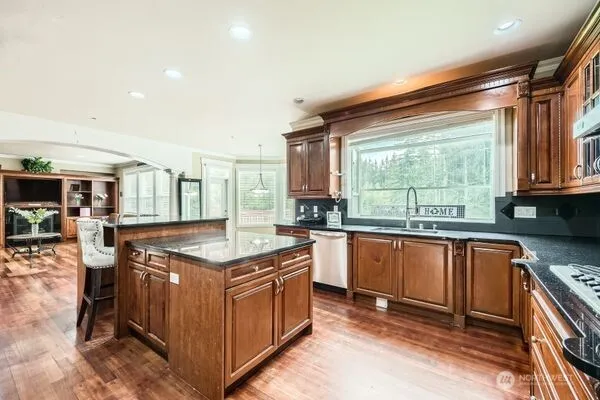 a kitchen with stainless steel appliances granite countertop a stove a sink and a refrigerator