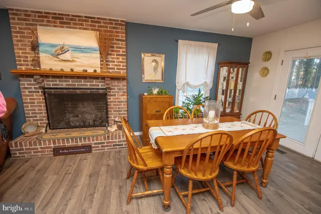 a view of a dining room with furniture wooden floor and a fireplace