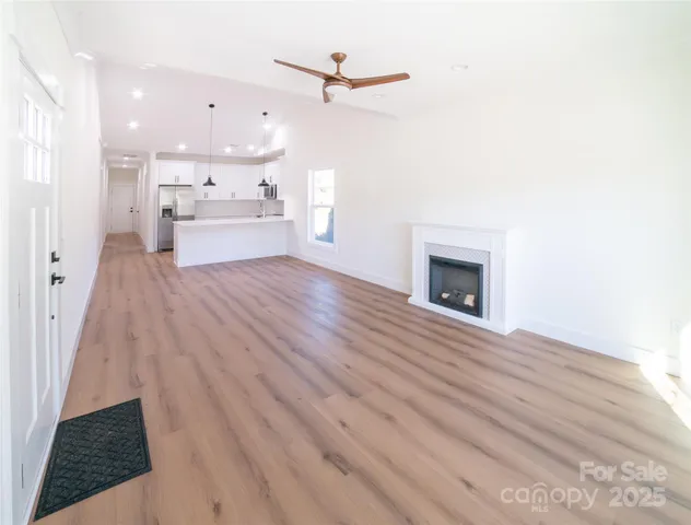 a view of a livingroom with wooden floor and a ceiling fan