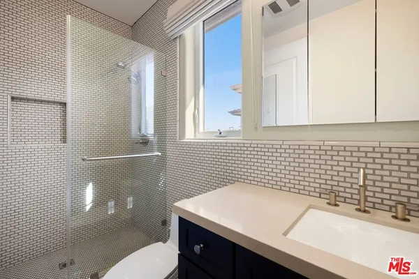 a bathroom with a sink a toilet and shower
