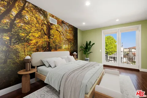 a bedroom with a large bed and a potted plant