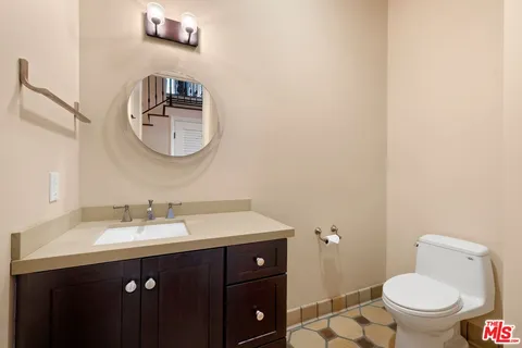 a bathroom with a toilet a sink and mirror