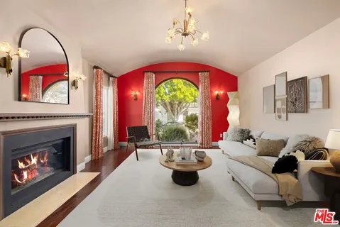 a living room with furniture a fireplace and a chandelier