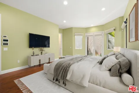 a spacious bedroom with a bed and a flat screen tv