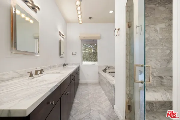 a spacious bathroom with a granite countertop sink mirror and shower