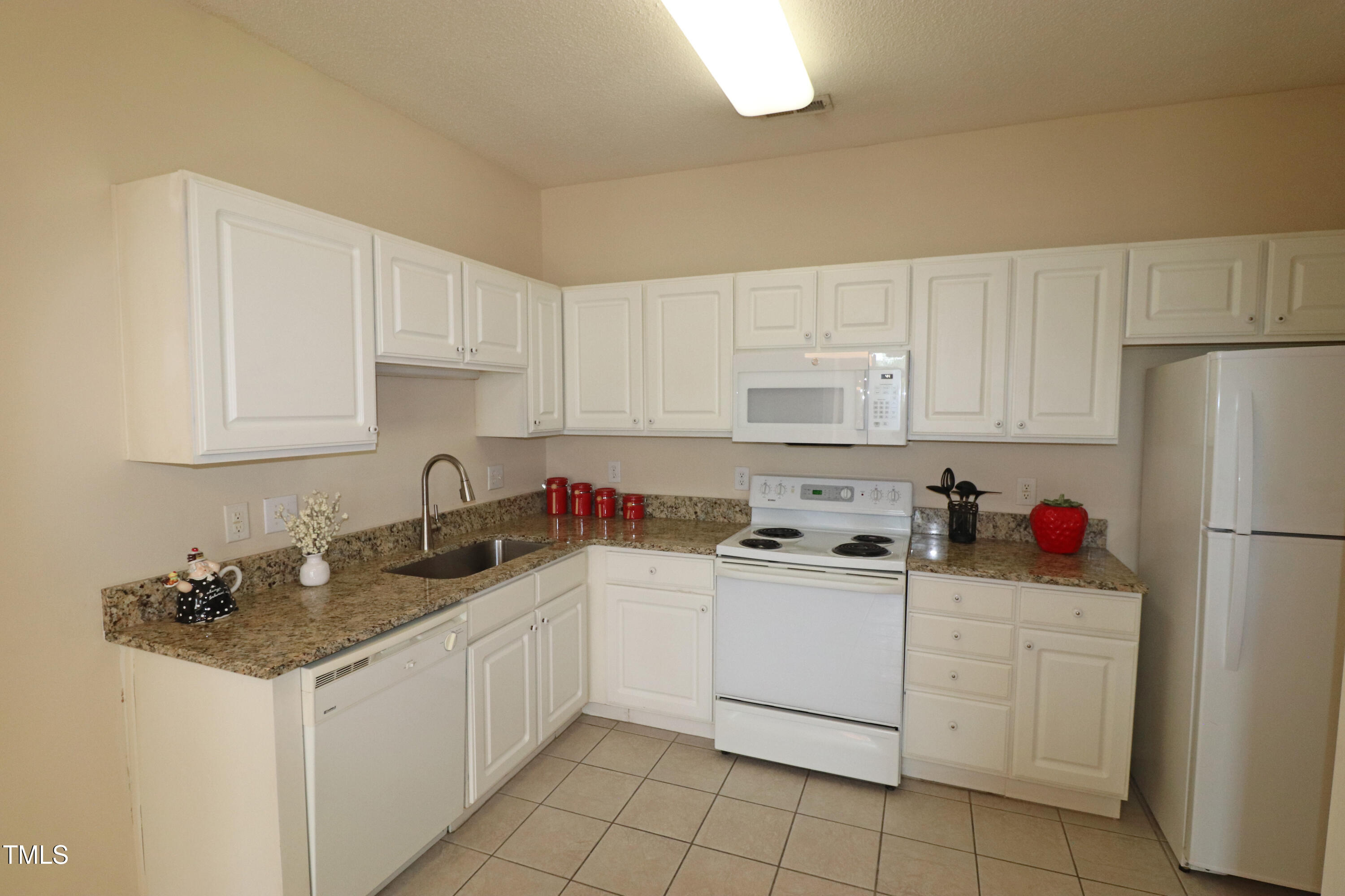 2520 Friedland Place, Unit 202 Raleigh, NC 27617 - Photo 12 of 32 a kitchen with white cabinets sink and white appliances