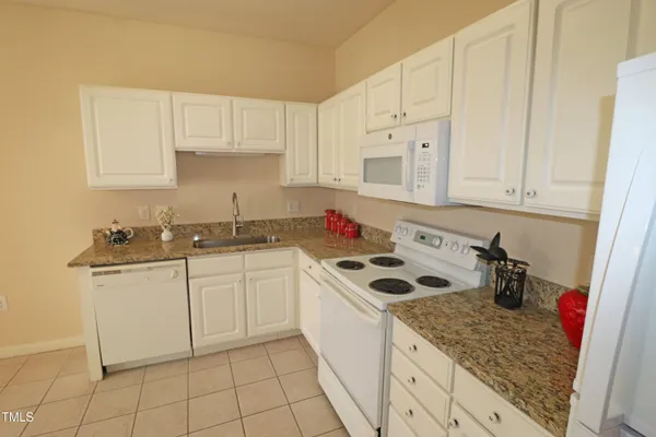 a kitchen with stainless steel appliances granite countertop a sink stove and white cabinets