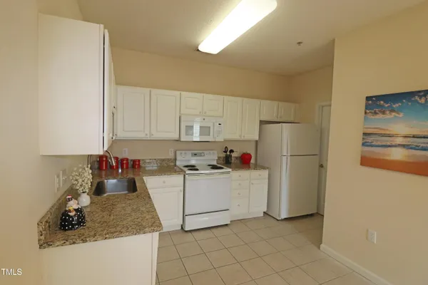 a kitchen with white cabinets and white appliances
