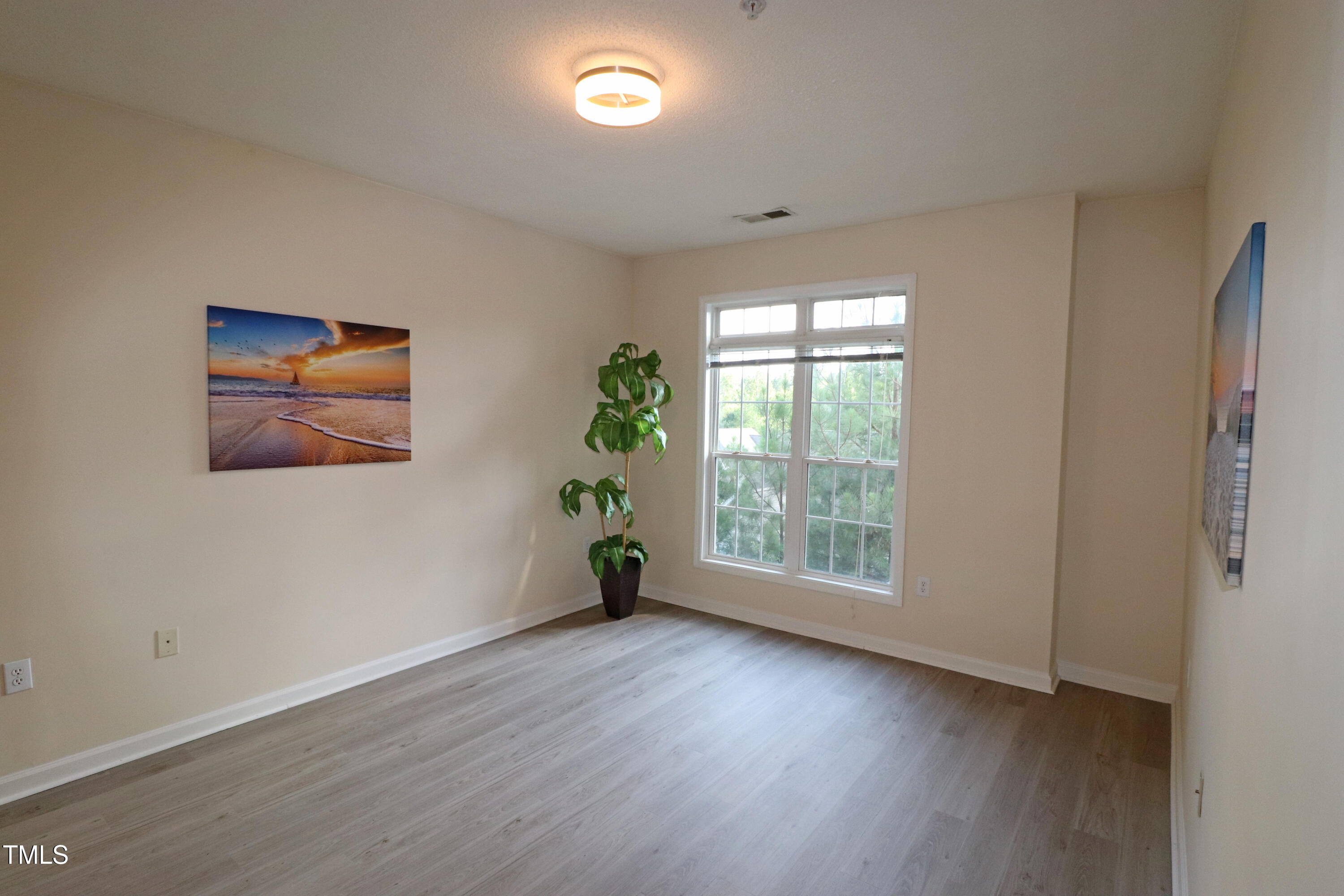 2520 Friedland Place, Unit 202 Raleigh, NC 27617 - Photo 17 of 32 an empty room with wooden floor and window