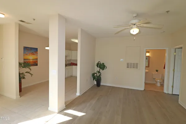a view of a hallway with wooden floor and a bathroom