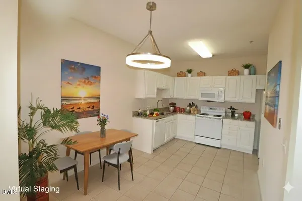 a kitchen with granite countertop white cabinets and white appliances