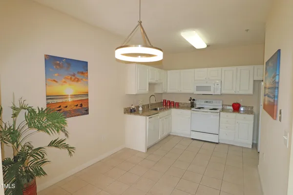 a kitchen with granite countertop a white cabinets and white appliances