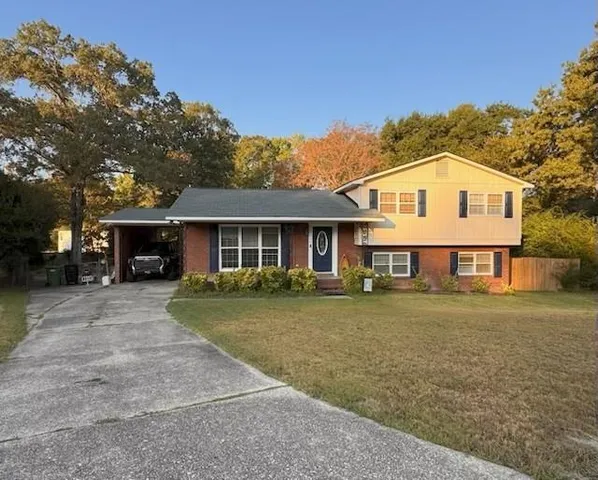 a front view of a house with a yard and trees
