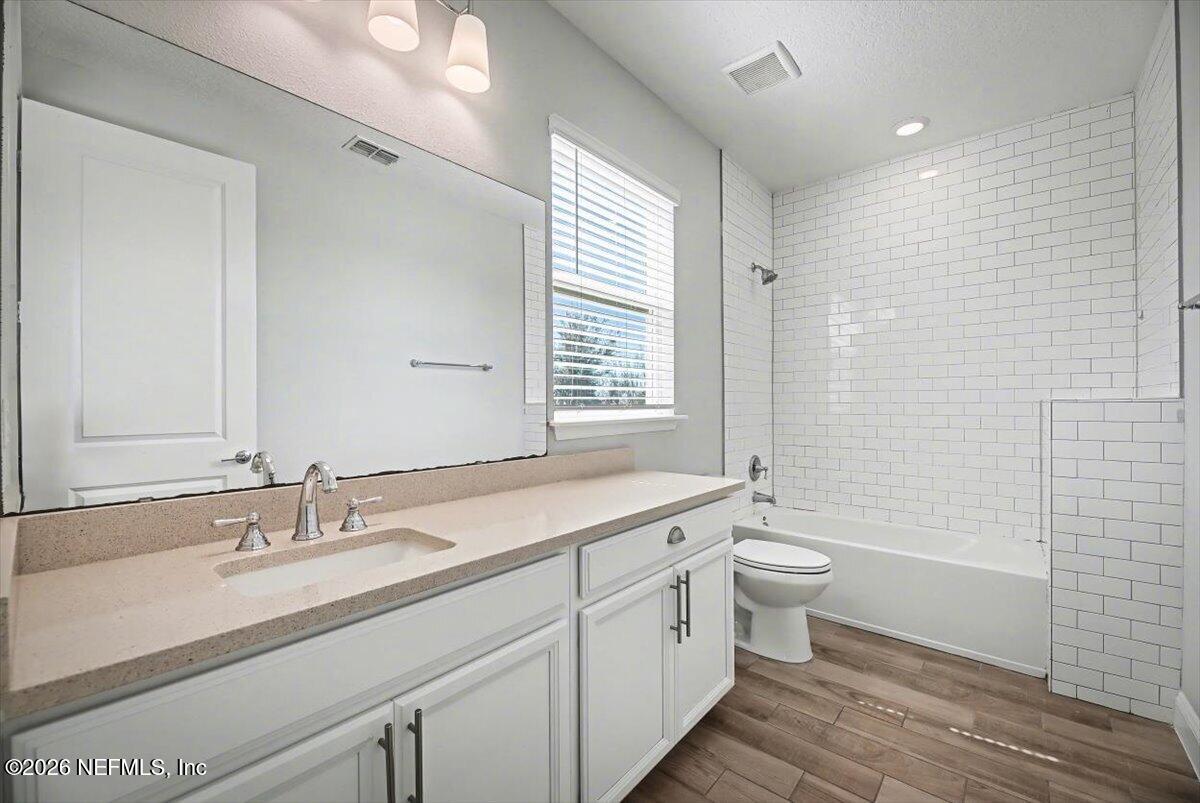 282 Caribbean Place St. Johns, FL 32259 - Photo 34 of 56 a bathroom with a granite countertop sink a toilet a mirror and bathtub