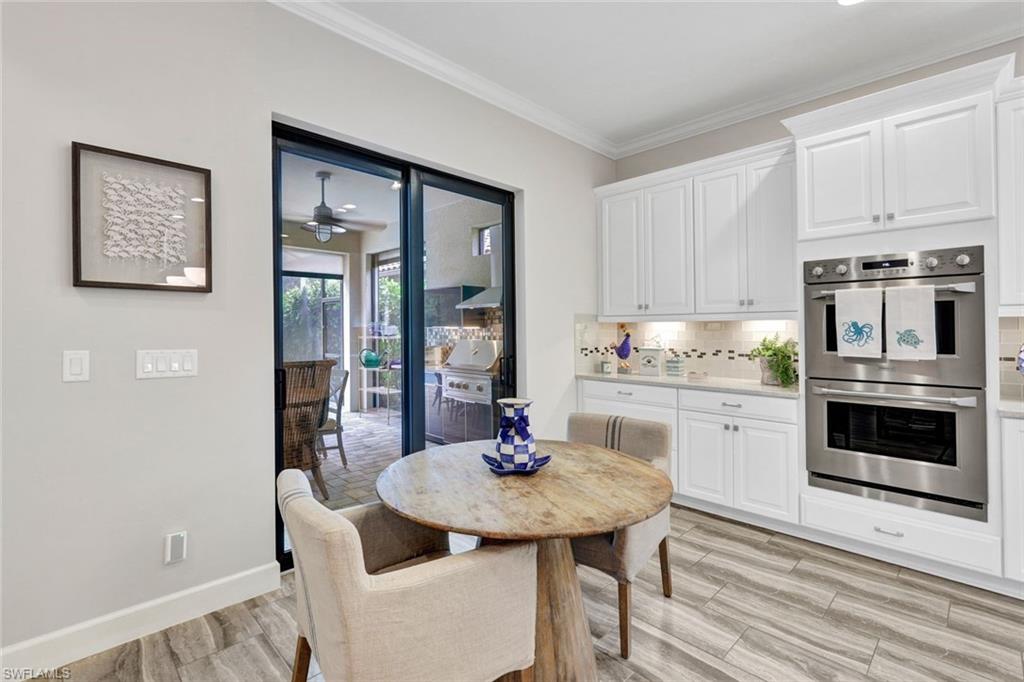 10163 Coconut Road Estero, FL 34135 - Photo 12 of 44 a kitchen with granite countertop white cabinets and stainless steel appliances